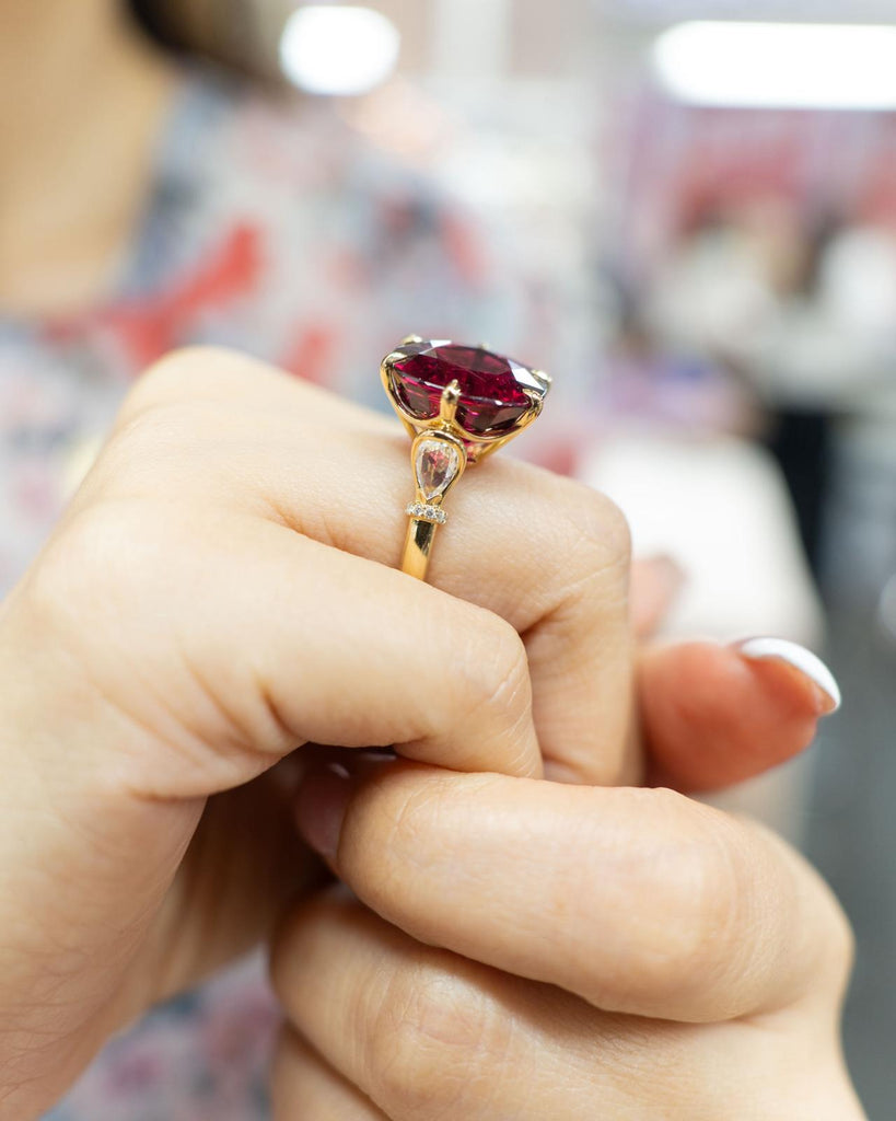 Elegant rubellite ring photographed on the finger for depth and brilliance
