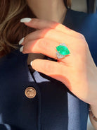 Close up view of 4.03ct Colombian emerald and diamond ring in PT900 platinum and 18K yellow gold on the hand