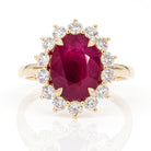 Top view of 4.01ct intense pinkish-red oval ruby diamond ring in 18K yellow gold, IGI certified, featuring halo of natural diamonds
