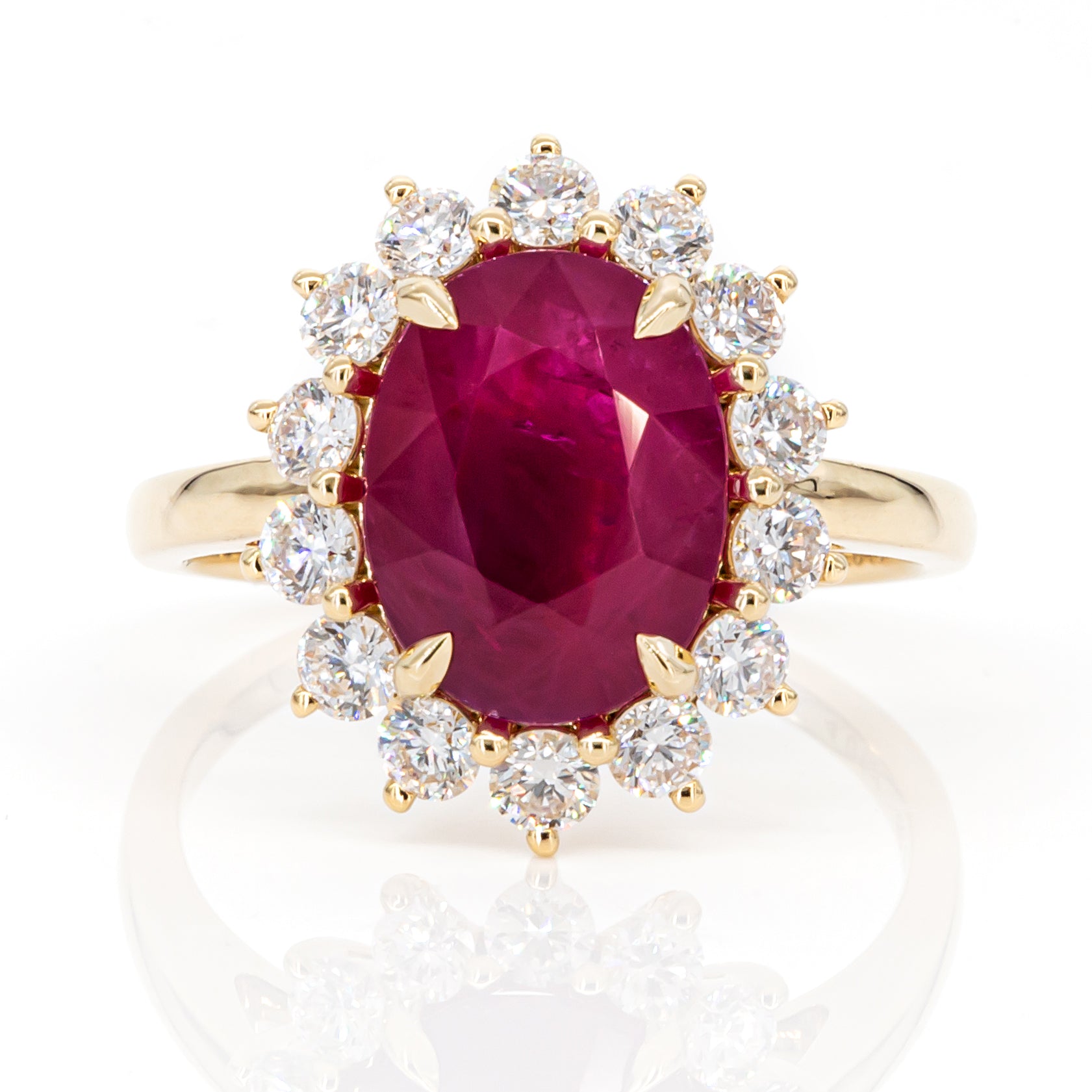 Top view of 4.01ct intense pinkish-red oval ruby diamond ring in 18K yellow gold, IGI certified, featuring halo of natural diamonds